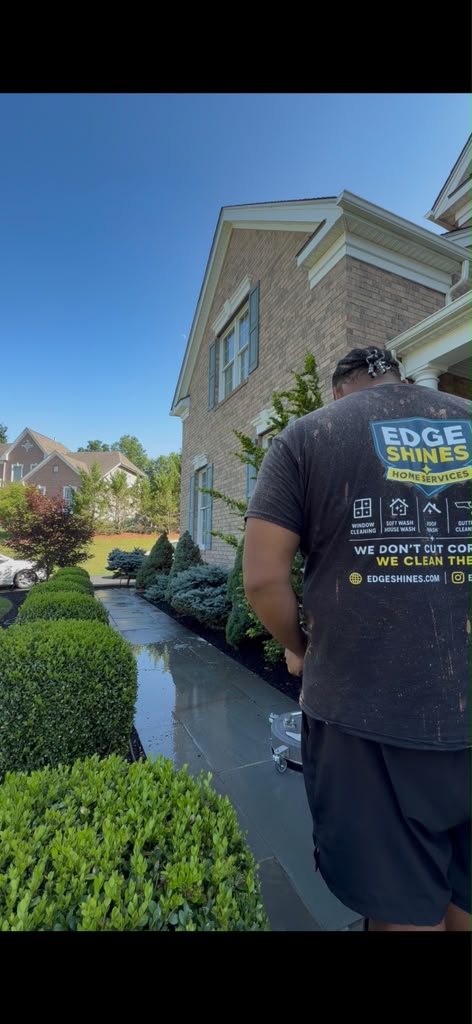 Edge Shines technician soft washing a brick home walkway