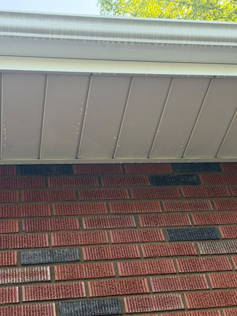 Clean white gutter and soffit above red brick siding