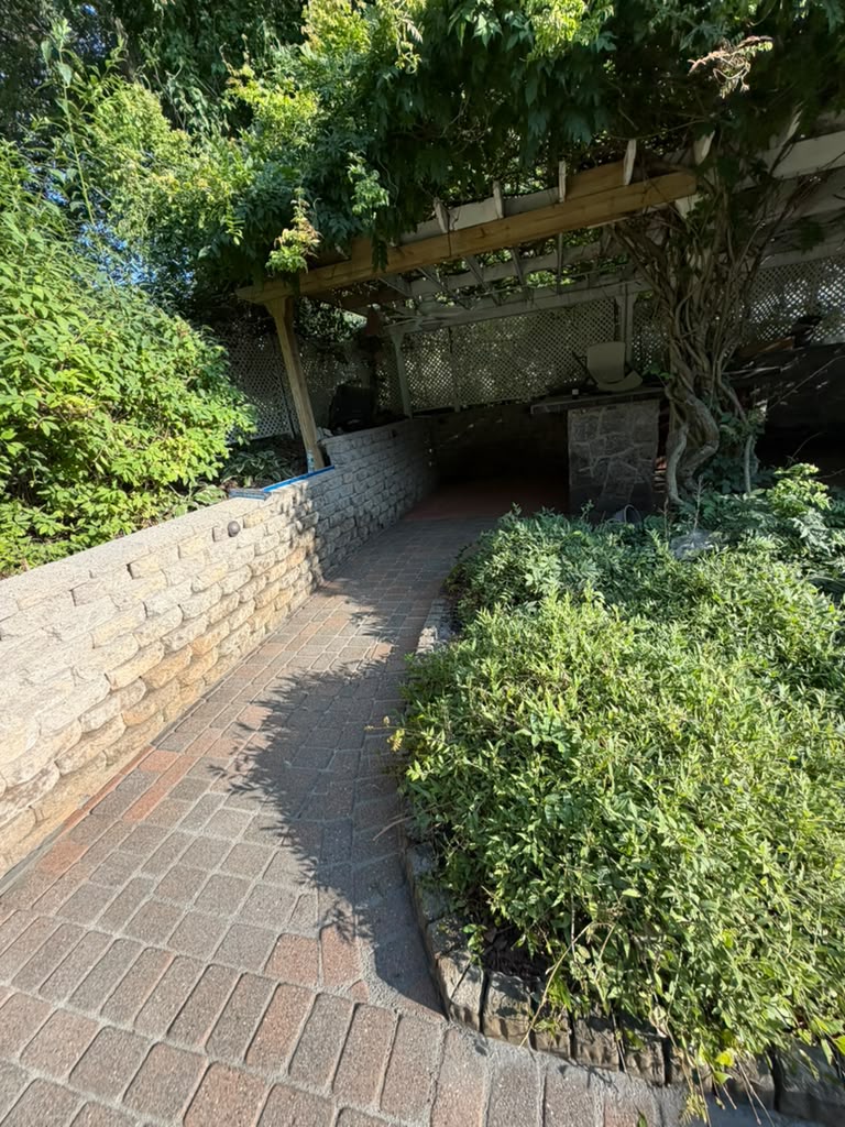Curved paver path along a stone garden wall